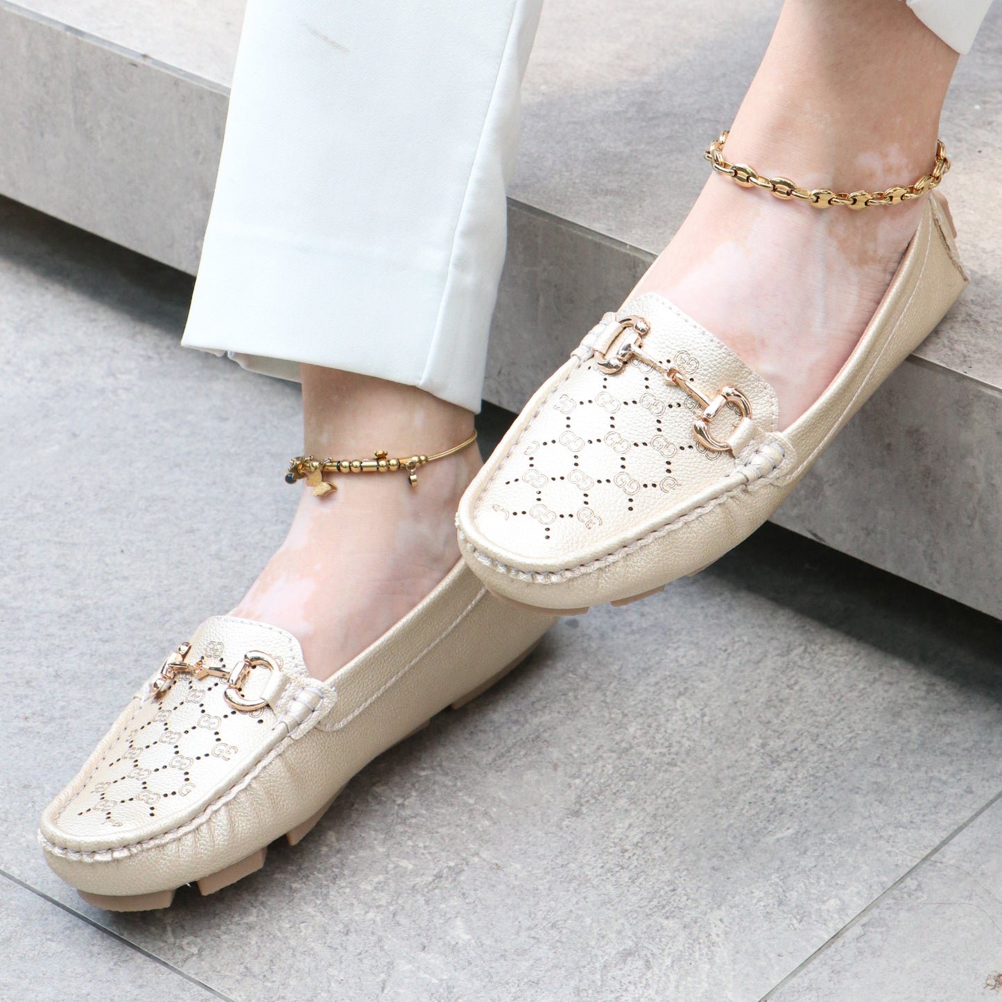 Mocasín dorado elegante con cadena decorativa