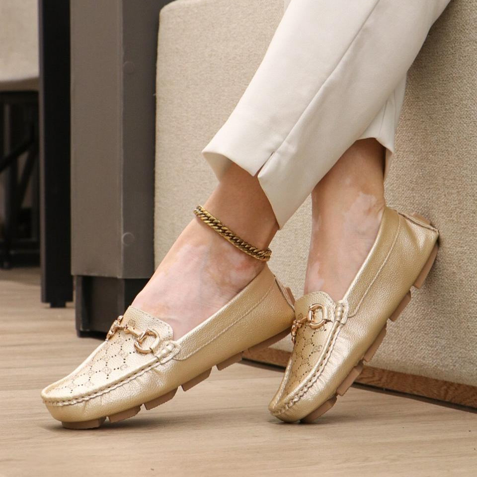 Mocasín dorado elegante con cadena decorativa