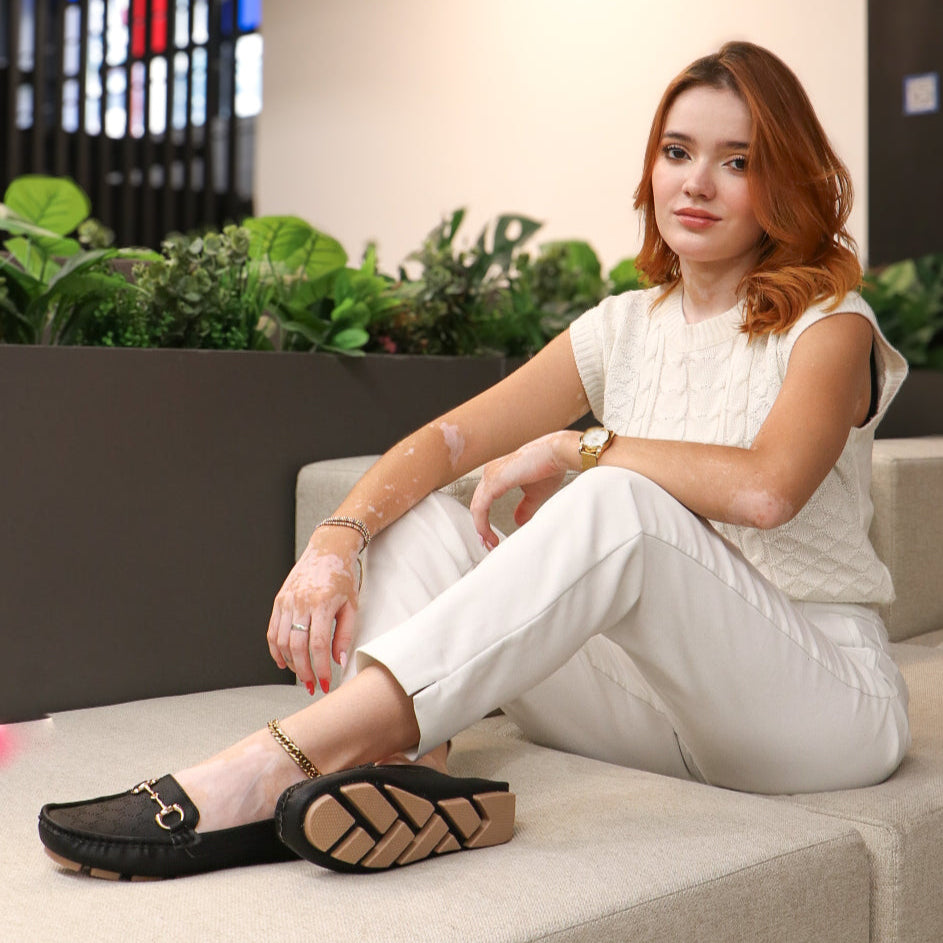 Mocasín dorado elegante con cadena decorativa